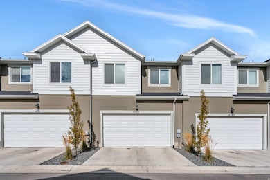 View of front facade with stucco siding, driveway, and a garage