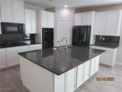 Kitchen featuring white cabinetry, black appliance