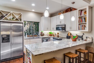 Kitchen with open shelves, stainless steel appliances, a peninsula, light stone countertops, and recessed lighting