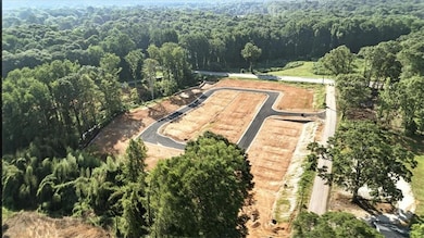 Aerial overview of property's location with a heavily wooded area