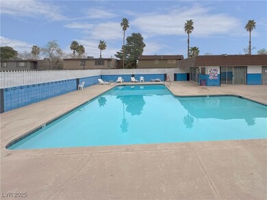 Community pool featuring a patio area and fence