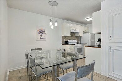 Dining area with light tile patterned flooring open to the kitchen