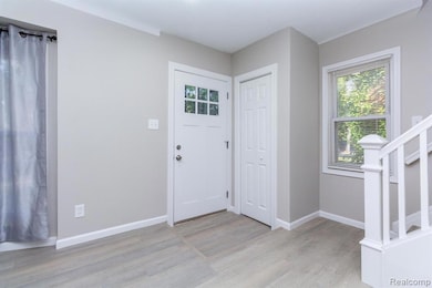 Foyer entrance with stairs and light wood-style flooring
