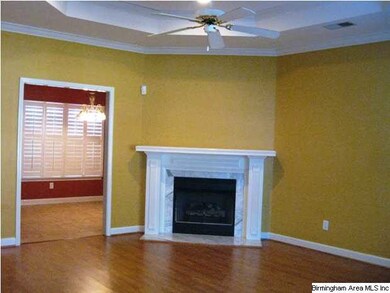 Gleaming hardwoods, a marble fireplace, tray ceili