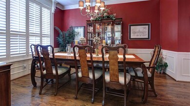 Beautifully sized and adorned formal dining room. Plantation shutters with custom cornices, handscraped hardwood floors and chandelier. Direct access into the kitchen.