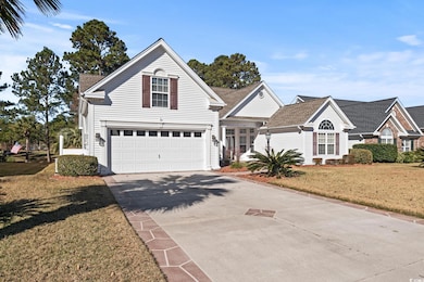 View of property featuring a front yard and a garage