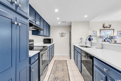Kitchen featuring a sink, light countertops, under