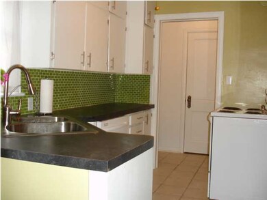 Kitchen has a tiled floor and backsplash