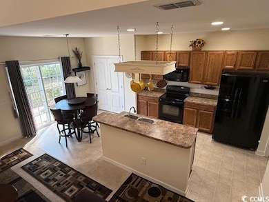 Kitchen featuring an island with sink, lofted ceil
