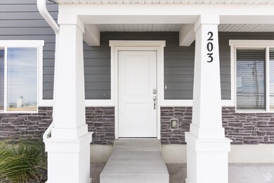 View of exterior entry with stone siding and a porch