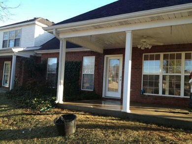 Back of home features plenty of brick and covered back porch.