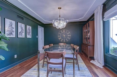Dining room featuring a chandelier, wood finished floors, and ornamental molding
