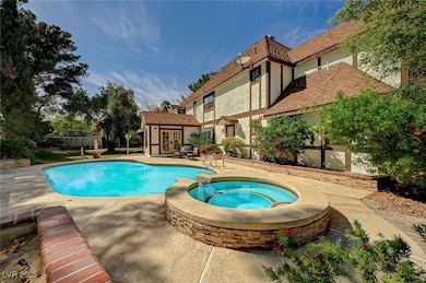 View of pool with french doors, fence, a pool with