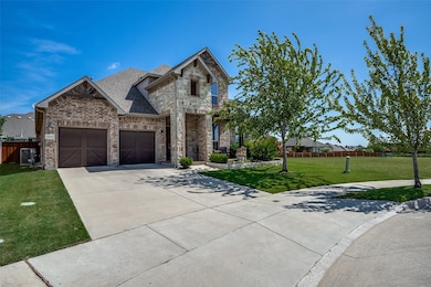 French country inspired facade with stone siding, concrete driveway, a shingled roof, brick siding, and an attached garage