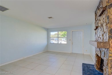 Unfurnished living room featuring light tile patte