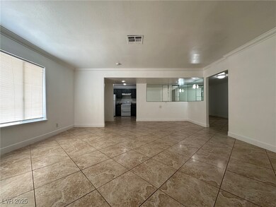 Spare room with ornamental molding, light tile patterned floors, and a textured ceiling