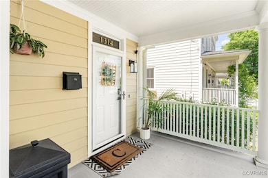 Doorway to property featuring covered porch