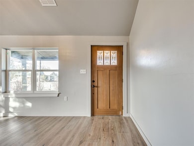 Entryway with wood finished floors and vaulted ceiling