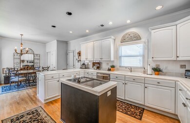Kitchen with white cabinetry, backsplash, and ligh