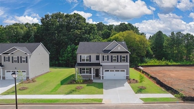 View of front of home with a garage and a front ya
