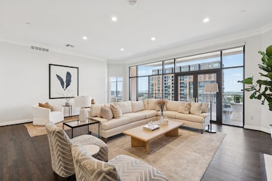 Living area with ornamental molding, recessed lighting, wood finished floors, and a city view