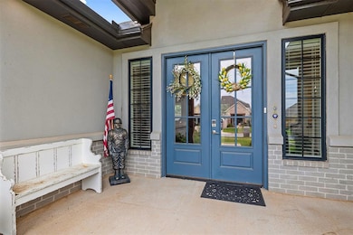 Entrance to property featuring french doors, stucco siding, a patio area, and brick siding