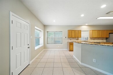 Bright, open kitchen and dining area with tiled fl