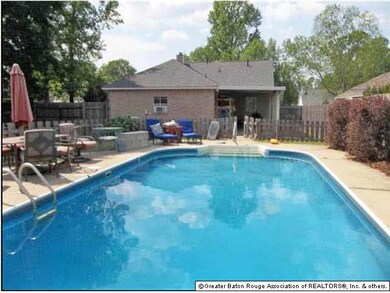 Large backyard with an in-ground pool and covered 