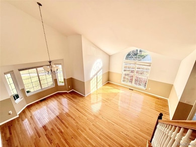 Unfurnished living room featuring light wood-style floors, a chandelier, and high vaulted ceiling