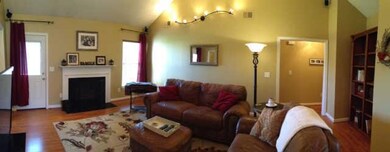 Spacious living room has vaulted ceilings and wired for surround sound.