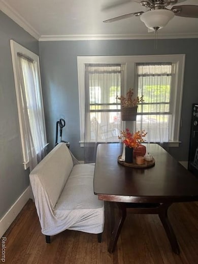 Dining area featuring a ceiling fan, wood finished floors, and ornamental molding