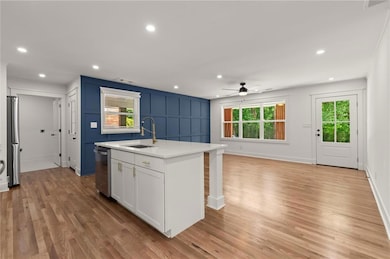 Kitchen with a sink, a ceiling fan, light countertops, healthy amount of natural light, and recessed lighting
