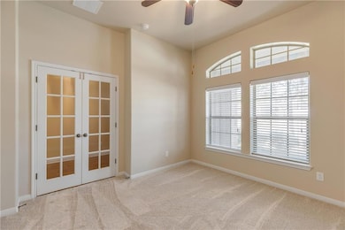 Carpeted spare room with french doors, baseboards