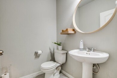 Half bath featuring a textured wall and baseboards