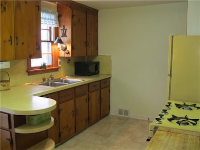 Kitchen. Charming knotty pine kitchen cabinets.