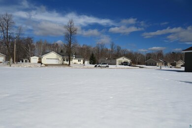 Yard covered in snow with a garage and a residenti