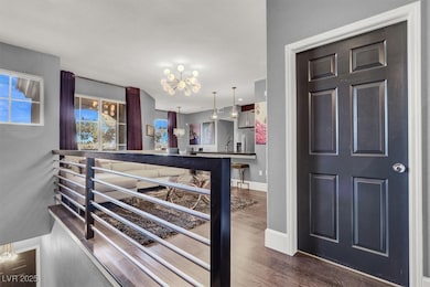Entrance foyer with baseboards, wood finished floors, and a notable chandelier