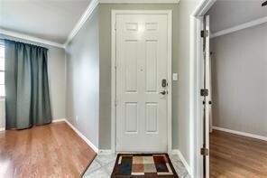 Entrance foyer with ornamental molding and dark hardwood / wood-style flooring