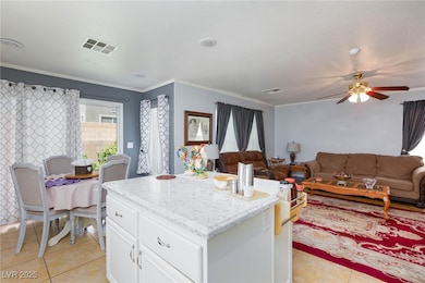 Kitchen with light tile patterned floors, white ca
