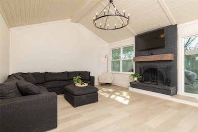 Living area featuring a fireplace, wood finished floors, a chandelier, plenty of natural light, and wooden ceiling
