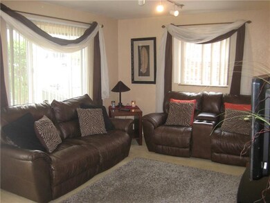 The living room includes two large windows that of