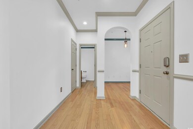 Hall featuring crown molding and light wood-type f