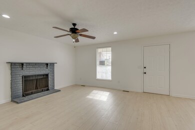 Enter the home into the spacious family room with ceiling fan and fireplace