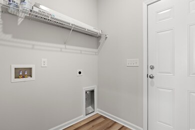 Laundry room with hardwood / wood-style floors, ho
