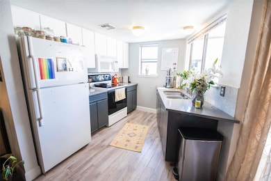 Kitchen featuring a sink, light wood-type floorin