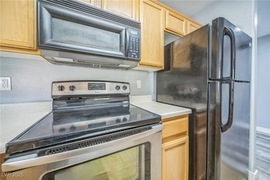 Kitchen featuring black appliances, light brown ca