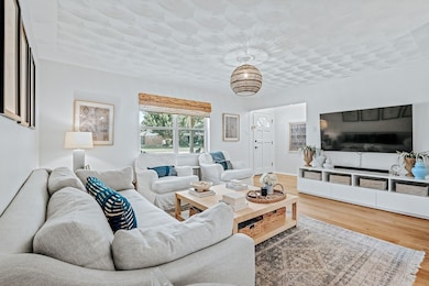 Living area with wood finished floors and a chandelier