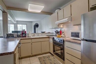 Kitchen featuring freestanding refrigerator, under