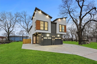 Back house at dusk featuring a yard and a garage