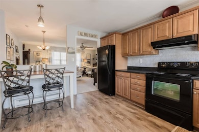 Kitchen with dark countertops, a kitchen bar, unde